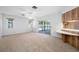 Comfortable living room with natural light, sliding glass doors to the patio, and a view of the backyard pool at 1211 Stony Brook Ln, Dunedin, FL 34698