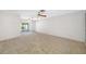 Spacious living area features neutral carpet and sliding doors to the backyard pool at 1211 Stony Brook Ln, Dunedin, FL 34698