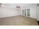 Large living room featuring neutral carpet, ceiling fan, and windows with natural light at 1211 Stony Brook Ln, Dunedin, FL 34698