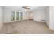 Bright living room with neutral carpet, ceiling fan, and shuttered windows allowing ample natural light at 1211 Stony Brook Ln, Dunedin, FL 34698
