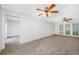 Spacious living room with a ceiling fan, windows, and doorway to another room at 1211 Stony Brook Ln, Dunedin, FL 34698
