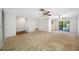 Open living room featuring neutral carpet, ceiling fan, and sliding doors out to the pool at 1211 Stony Brook Ln, Dunedin, FL 34698