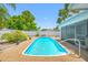Outdoor swimming pool with gravel surround and fenced yard at 1211 Stony Brook Ln, Dunedin, FL 34698