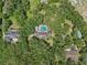 Aerial shot showcasing home with screened pool nestled among lush green trees at 12433 Kelso Rd, Thonotosassa, FL 33592