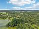 Vast aerial panorama highlights the property's tranquil setting with lakefront and abundant greenery at 12433 Kelso Rd, Thonotosassa, FL 33592