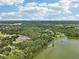 Expansive aerial view showcases the property's serene lakefront setting and lush green surroundings at 12433 Kelso Rd, Thonotosassa, FL 33592