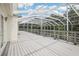Enclosed porch with a grey floor and screened views of the sky and backyard trees at 12433 Kelso Rd, Thonotosassa, FL 33592