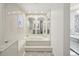 Bright neutral bathroom featuring a large tub, framed mirrors, and grey floors at 12433 Kelso Rd, Thonotosassa, FL 33592