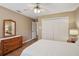 Well-lit bedroom featuring a ceiling fan, closet, dresser, and connecting doors at 12433 Kelso Rd, Thonotosassa, FL 33592