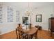 Elegant dining room with hardwood floors, chandelier, and view into the kitchen at 12433 Kelso Rd, Thonotosassa, FL 33592