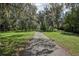 Long driveway leading to a secluded property with mature trees and lush landscaping at 12433 Kelso Rd, Thonotosassa, FL 33592
