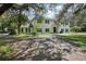 A charming two-story home with black shutters and a beautiful front yard framed by mature trees at 12433 Kelso Rd, Thonotosassa, FL 33592