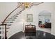 Bright foyer with wood staircase, chandelier, dark wood floors, and arched doorway to living area at 12433 Kelso Rd, Thonotosassa, FL 33592