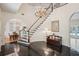 Open foyer with wood staircase, chandelier, dark wood floors, and view to dining and living areas at 12433 Kelso Rd, Thonotosassa, FL 33592