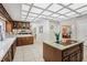 The kitchen features a cooktop island, unique ceiling, and a view into the living and dining rooms at 12433 Kelso Rd, Thonotosassa, FL 33592