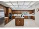The kitchen offers stainless appliances, ample wood cabinetry, a center island, and unique lighting at 12433 Kelso Rd, Thonotosassa, FL 33592