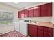 Bright laundry room featuring a washer, dryer, sink, and storage cabinets at 12433 Kelso Rd, Thonotosassa, FL 33592