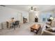 Spacious living room with a desk area, couch, and access to the outside through glass paneled doors at 12433 Kelso Rd, Thonotosassa, FL 33592