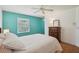 Bright main bedroom featuring a turquoise accent wall, parquet floors, and white trim at 12433 Kelso Rd, Thonotosassa, FL 33592