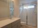 Bathroom featuring a vanity with solid surface countertop and a large shower stall with glass doors at 19643 Shady Oak Dr, Land O Lakes, FL 34638