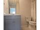 Cozy bathroom featuring a blue vanity, a large mirror, and a toilet under a shower with leaf curtain at 19643 Shady Oak Dr, Land O Lakes, FL 34638