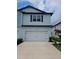 Charming two-story home with a white garage door and light blue siding at 19643 Shady Oak Dr, Land O Lakes, FL 34638
