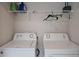 Bright laundry room features an Amana washer and dryer, with a wire shelf for extra storage and organization at 19643 Shady Oak Dr, Land O Lakes, FL 34638