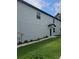 Side view of a home featuring light blue siding and a well-maintained lawn at 19643 Shady Oak Dr, Land O Lakes, FL 34638