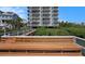 Exterior view of a condo building with a dock and bench in front, perfect for relaxation and enjoying the scenery at 19925 Gulf Blvd # 407, Indian Shores, FL 33785