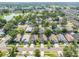 Aerial view showcasing a quiet residential neighborhood with tree-lined streets and a nearby lake at 2024 Glen Forge St, Brandon, FL 33511