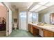 Bright main bathroom featuring a double vanity, a toilet, a walk-in shower, and natural lighting at 2024 Glen Forge St, Brandon, FL 33511
