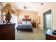 Spacious main bedroom with high ceilings, a king-sized bed, dark wood furniture, and a full bathroom at 2024 Glen Forge St, Brandon, FL 33511