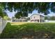 Spacious backyard featuring a well-maintained lawn, white fencing, and a screened-in porch on the home at 205 W 122Nd Ave, Tampa, FL 33612