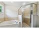 Bright bathroom featuring a tub and glass enclosed shower with tiled walls at 205 W 122Nd Ave, Tampa, FL 33612