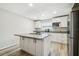 Bright kitchen with island, stainless steel refrigerator, granite counters, and new flooring at 205 W 122Nd Ave, Tampa, FL 33612