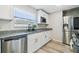 Well-lit kitchen featuring granite counters, stainless appliances, and white cabinetry at 205 W 122Nd Ave, Tampa, FL 33612