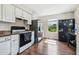 Bright kitchen with white cabinetry, stainless steel refrigerator, and black appliances at 205 W 122Nd Ave, Tampa, FL 33612