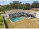 Aerial view of a screened-in pool with an attached outdoor patio, surrounded by greenery at 205 W 122Nd Ave, Tampa, FL 33612