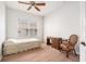 This bedroom includes wood floors, a ceiling fan, and a large window at 21007 Sunpoint Way # 203, Lutz, FL 33558