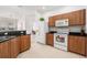 Kitchen with dark granite counters, white appliances, and wood cabinets at 21007 Sunpoint Way # 203, Lutz, FL 33558