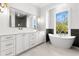 Bright bathroom with dual vanity, freestanding tub, and window with natural light at 218 Hesperides N St, Tampa, FL 33609