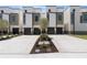 Modern townhome exterior featuring a clean facade, dark garage doors, and a landscaped front at 218 Hesperides N St, Tampa, FL 33609