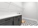 Laundry room with gray cabinets, quartz countertop, and patterned tile floors at 218 Hesperides N St, Tampa, FL 33609