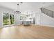 Open-concept home with light hardwood floors, staircase, sliding glass doors and modern kitchen at 218 Hesperides N St, Tampa, FL 33609
