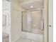 Bathroom features a tub and shower combination with sliding glass doors, plus a white tiled surround at 2216 Evans Rd, Clearwater, FL 33763