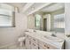 Bathroom with double vanity, a large mirror, and tile flooring at 2216 Evans Rd, Clearwater, FL 33763
