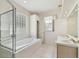Bright bathroom featuring a glass shower, soaking tub, and a large window at 2216 Evans Rd, Clearwater, FL 33763