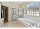 Bathroom featuring a soaking tub, glass shower, and a block window at 2216 Evans Rd, Clearwater, FL 33763