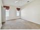 Bedroom with carpeted floors and two windows with burgundy curtains at 2216 Evans Rd, Clearwater, FL 33763