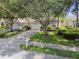 Landscaped front yard with mature trees shading the driveway, mailbox, and lush green grass at 2216 Evans Rd, Clearwater, FL 33763